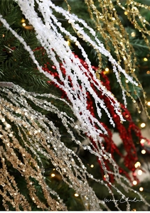 Close-up of glittery Christmas berry stems and sequins spray on a decorated Xmas tree