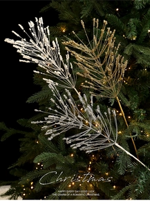 Close-up of three glittered Christmas feather picks in gold, silver, and white colors