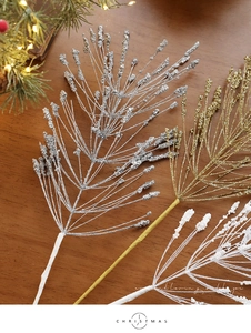 Close-up of sparkling glitter Christmas picks in gold, silver and white on wood surface