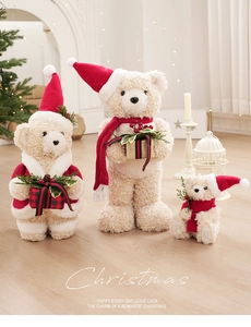 Detailed view of three white plush Christmas bears with red hats and holiday scarves