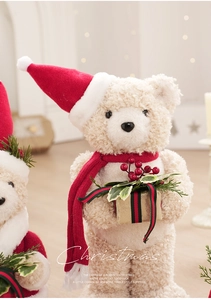 Close-up of plush teddy bear with red Christmas scarf and decorative golden gift box
