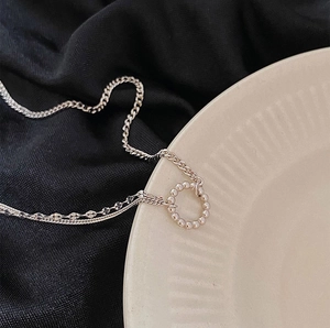 Detail of layered S925 silver chain necklace with circular bead pendant on silk