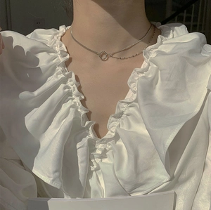 Close-up of layered S925 silver necklace with double chains and a round ring pendant