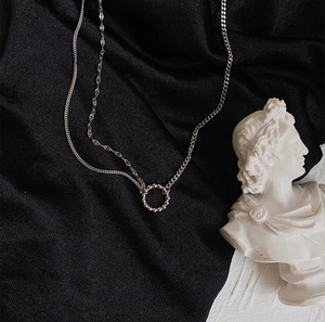 Detail of silver S925 multilayer choker necklace with circular beads on black fabric
