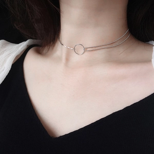 Gros plan d'un collier double épaisseur en argent S925 avec pendentif rond minimaliste