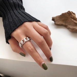 Detailed view of silver Cuban link chain ring worn on finger with minimalist aesthetic