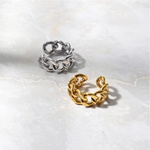 Close-up of gold and silver cuban chain link open rings on white marble background