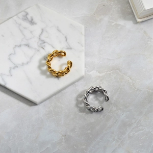 Detail of twisted chain link adjustable rings in gold and silver on marble display