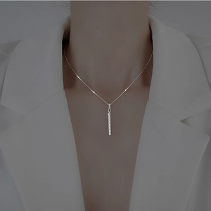 Minimalist silver bar pendant necklace with sparkling cubic zirconia on a female model