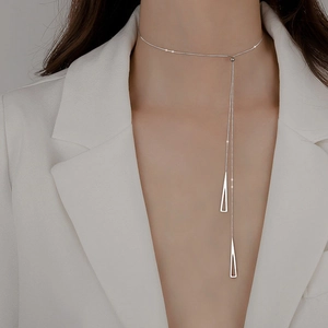 Detailed view of silver choker necklace with double tassels and geometric triangles