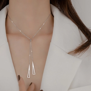 Detail of silver geometric Y-necklace with triangular fringe charms on model wear