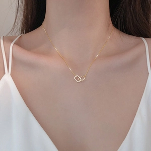Close-up of interlocking geometric gold square pendants set with shimmering cubic zirconia