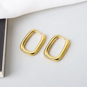 Close-up of gold-plated U-shaped earrings with a polished geometric rectangular finish