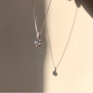 Macro detail of teardrop zircon pendant necklace with brilliant cut stone on box chain