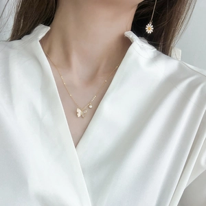 Close-up of elegant gold butterfly pendant necklace with micro-pave zircons on a model