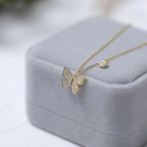 Elegant gold butterfly pendant necklace with cubic zirconia on a velvet jewelry box
