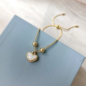 Bracelet cœur doré ajustable avec perles et nacre sur boîte texturée bleue