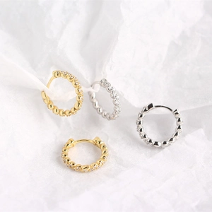 Close-up of gold and silver S925 sterling silver hoop earrings with zircon and beaded texture