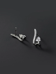 Détail de boucles d'oreilles ondulées argentées avec pavé de zircons cubiques