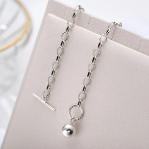 Detail of 925 silver beaded necklace with round pendant and toggle clasp closure