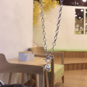 Detail of silver OT toggle clasp and glossy ball pendant on minimalist chain necklace