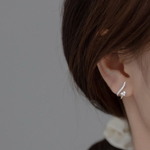 Élégante boucle d'oreille courbée en argent avec zircon en forme de cœur sur modèle