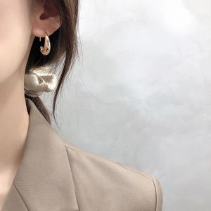 Polished 925 sterling silver C-shaped hoop earrings in gold finish on model