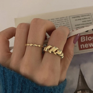 Ensemble de bagues torsadées plaquées or 18 carats avec tricot bleu et fond de magazine chic