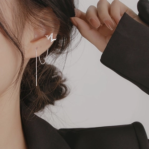 Macro shot of silver lightning bolt ear cuff with sparkling stones and chain tassel