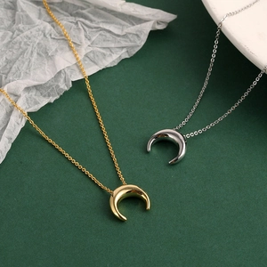 Collier croissant de lune minimaliste en or et argent sur un fond élégant et chic