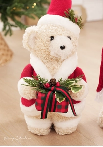 Detail of Christmas teddy bear in Santa outfit holding a plaid gift box ornament