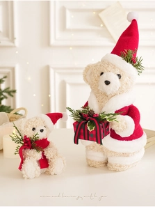 Detail of plush Christmas teddy bears with red scarves, pine branches and gift boxes