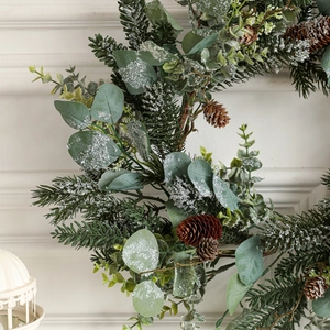Lush snowy Christmas garland with eucalyptus, pine needles and cones for holiday mantel decor