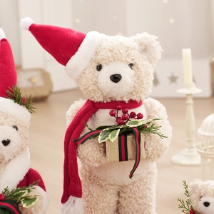 Sherpa teddy bear in Christmas hat and scarf holding a gift box for holiday decoration
