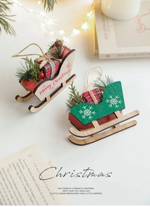 Detail of wooden Christmas sled ornaments with pine needles and plaid gift boxes
