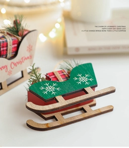 Detail of wooden Christmas sleigh ornament with Merry Christmas text and pine needles