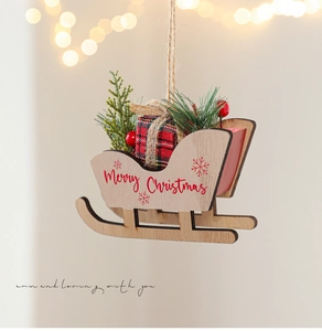 Close-up of wooden Christmas sleigh ornament with Merry Christmas text and red gift bag