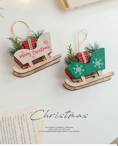 Close-up of wooden Christmas sleigh ornaments with pine needles and berries
