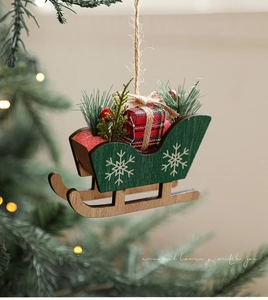 Detailed view of a green wooden Christmas sleigh ornament with plaid gift boxes and pine