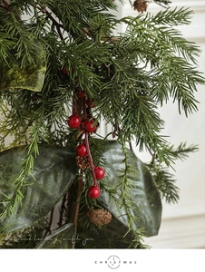 Details von Kiefernnadeln, roten Beeren und Zapfen an einem festlichen Weihnachtskranz