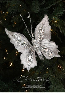 Close-up of a silver butterfly ornament with glitter and gems on a Christmas tree branch