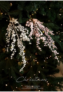 Close-up of glittery white and pink Christmas berry picks on a festive lighted tree