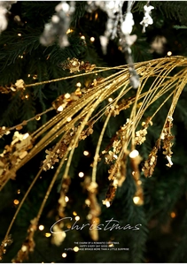 Macro shot of gold glittered Christmas wheat spikes with sparkling sequins on pine branches