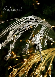 Close-up of glitter sprigs with silver sequins on a Christmas tree with bokeh lights