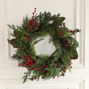Üppiger Weihnachtskranz mit Zapfen und roten Beeren an einer weißen Holztür