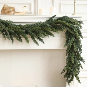 Lush evergreen pine garland draped on a white fireplace for elegant Christmas decor