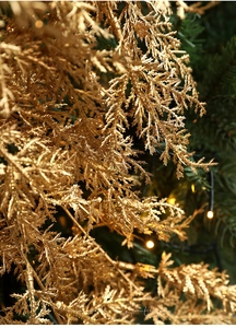Détail d'une branche de Noël dorée scintillante avec lumières LED chaleureuses