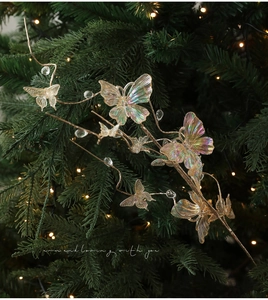 Close-up of holographic butterfly ornaments and crystal beads on a Christmas tree garland