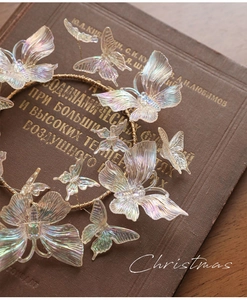 Macro shot of iridescent butterfly ornaments on golden wire over vintage book background
