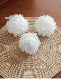 Close-up of white petal foam Christmas ball ornaments with intricate lace and fabric texture